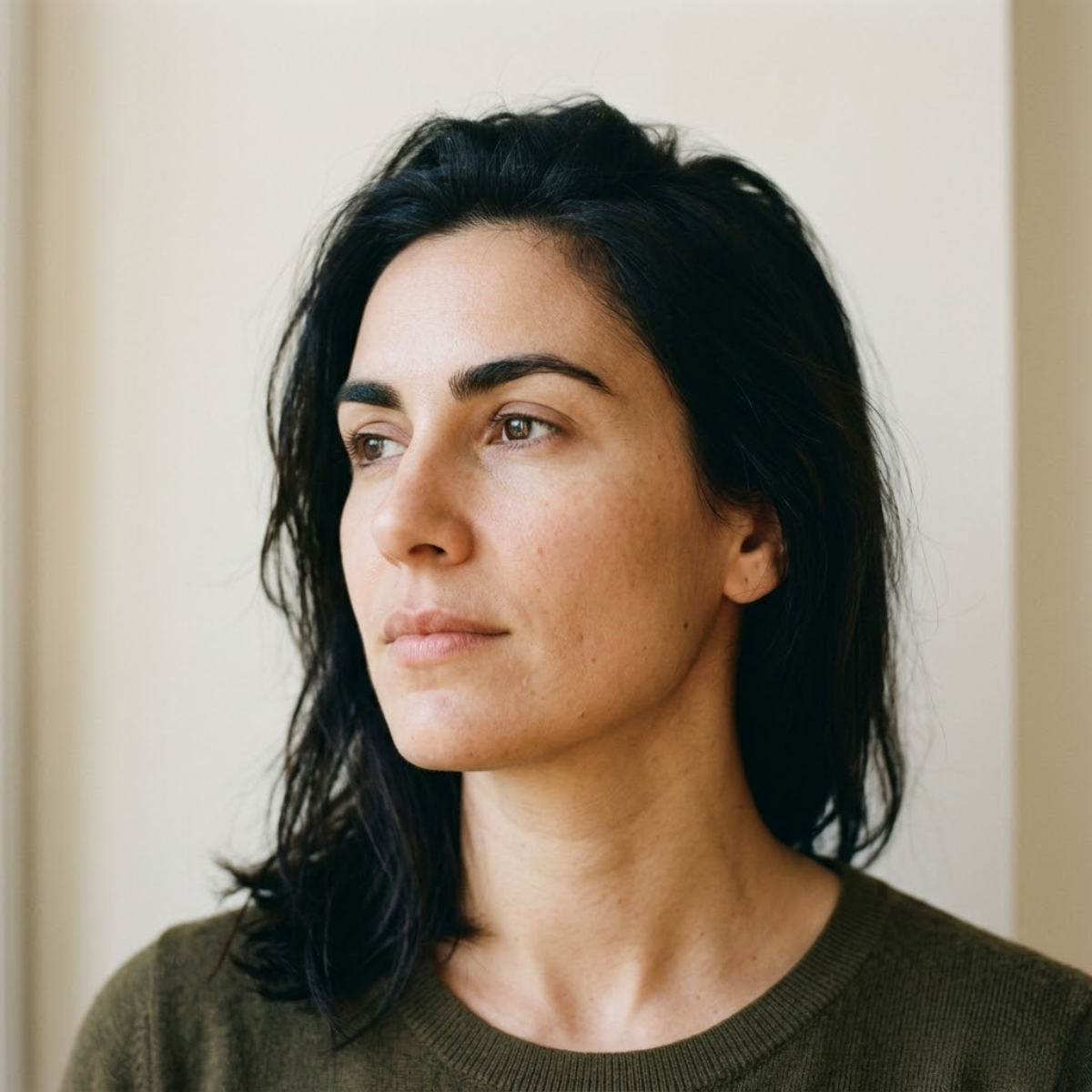 Close portrait of a woman with natural skin examining her facial hair