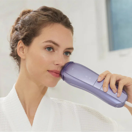Woman using Ulike Air 10 IPL device for facial hair removal at home in the UK